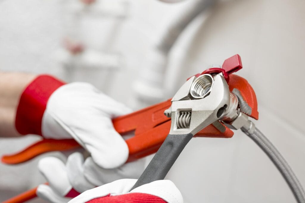 Plumber holding pipe wrenches for an emergency repair in Fort Lauderdale