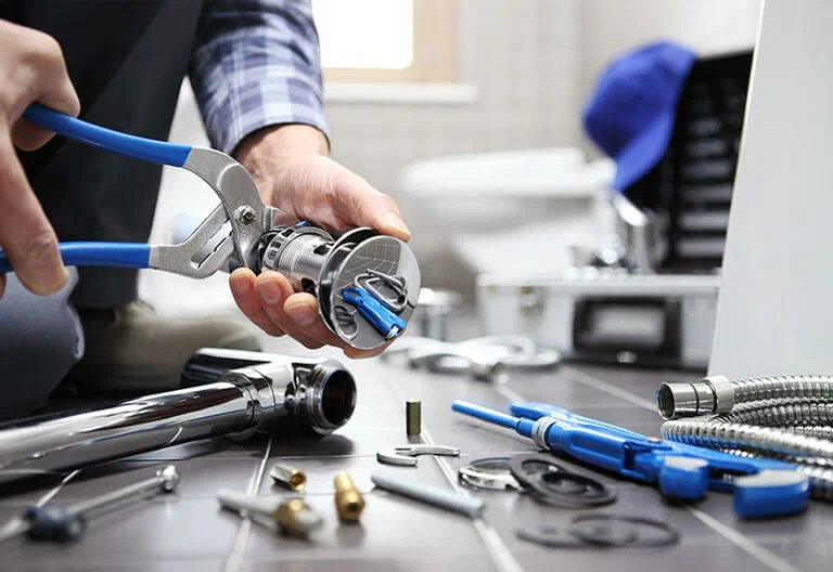 Technician repairing a plumbing fixture with professional tools in Fort Lauderdale