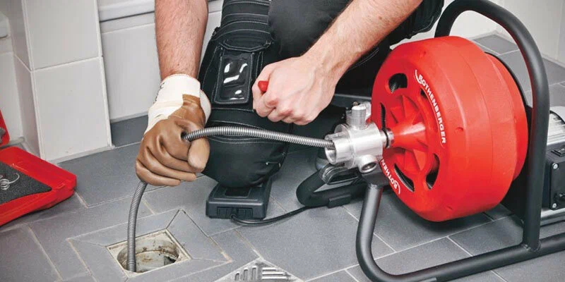 Plumber using a drain-cleaning machine in Fort Lauderdale