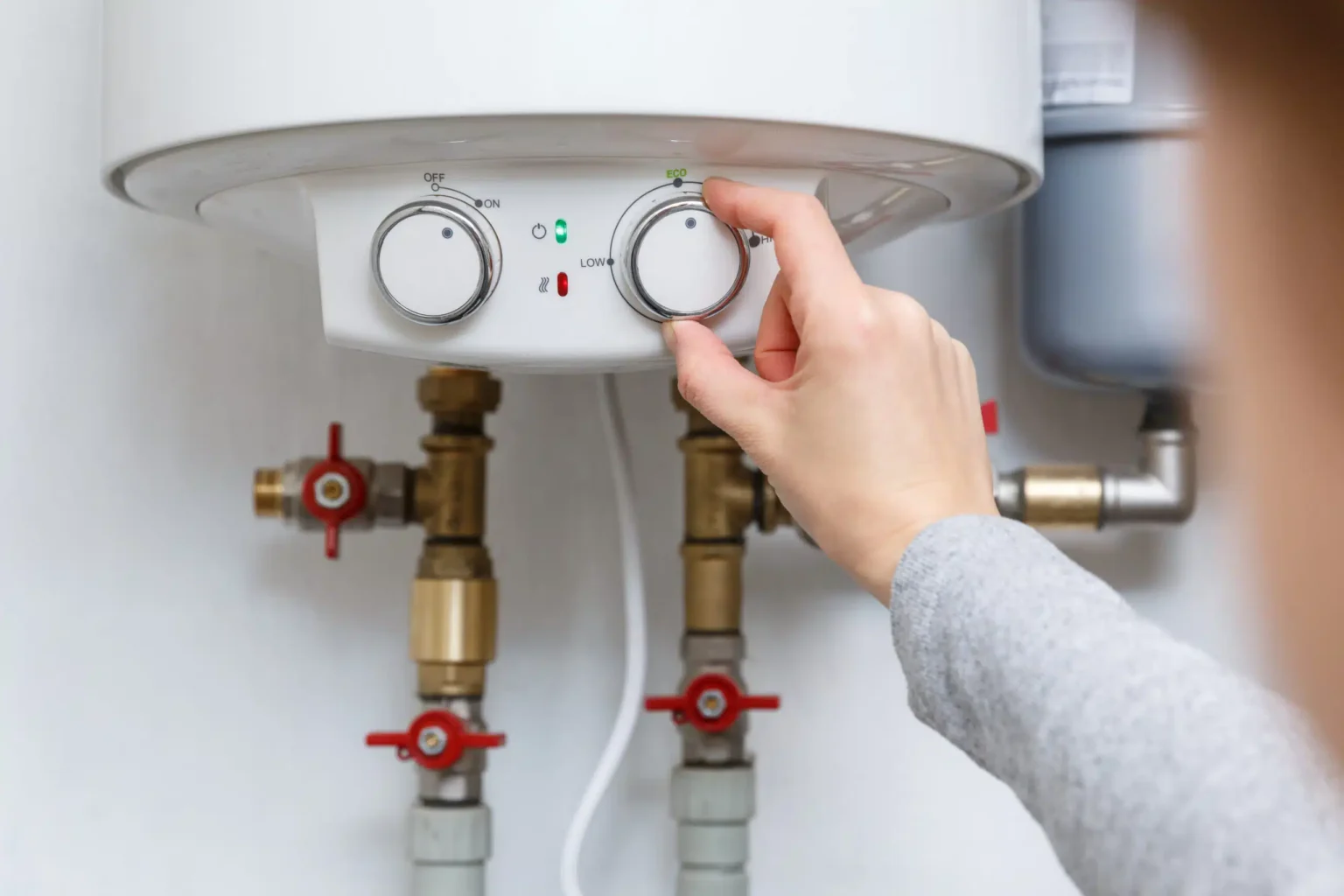 Homeowner adjusting the temperature controls on a water heater in Fort Lauderdale